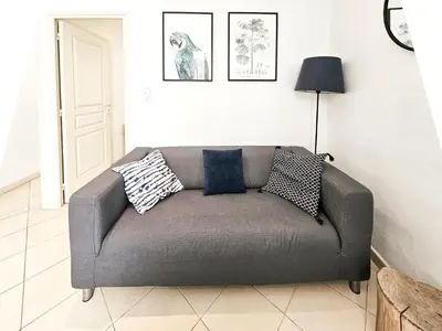 a couch in a living room with pillows on it at Fontaine 4 Pers AC WiFi in Nice