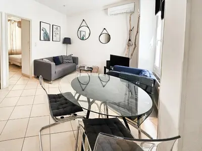 a living room with a glass table and chairs at Fontaine 4 Pers AC WiFi in Nice
