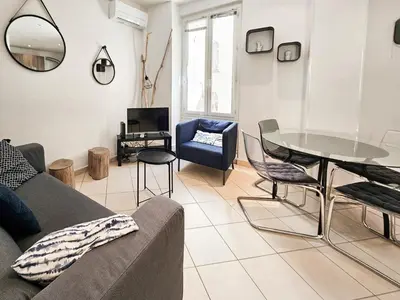 a living room with a couch and a table and chairs at Fontaine 4 Pers AC WiFi in Nice