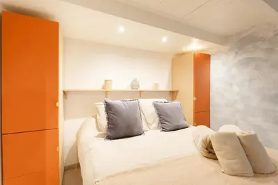 a bedroom with a bed with orange and blue pillows at New- Cozy apartment -4 guests - Air conditioning in Nice