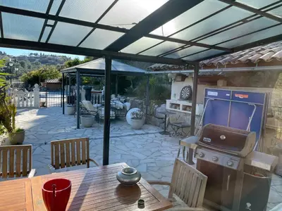 a patio with a grill and a wooden table at Beautiful villa Nice in Nice