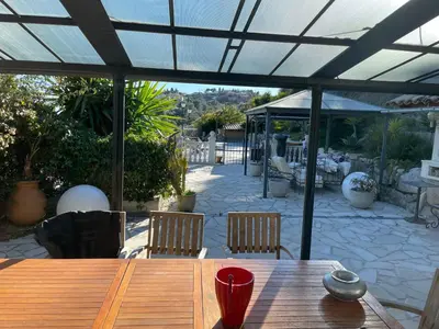 a wooden table sitting on a patio under a roof at Beautiful villa Nice in Nice