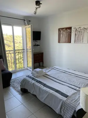 a bedroom with a bed and a large window at Beautiful villa Nice in Nice