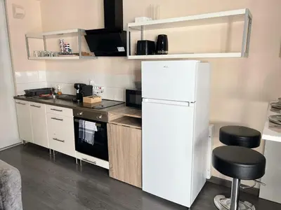 a kitchen with a white refrigerator and two stools at Studio élégant avec balcon près de la plage à Nice in Nice