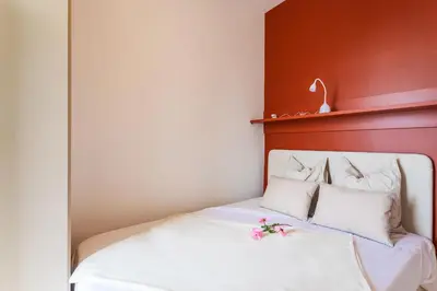 a bed with white sheets and pink flowers on it at TERRACOTTA AP4457 By Riviera Holiday Homes in Villefranche-sur-Mer