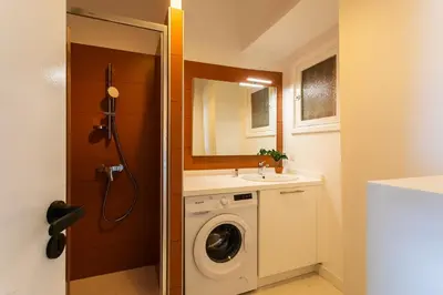 a bathroom with a washing machine and a sink at TERRACOTTA AP4457 By Riviera Holiday Homes in Villefranche-sur-Mer