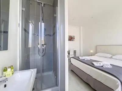 a bathroom with a shower and a bed and a tub at Nestor&Jeeves - PALAIS LASCARIS - Port in Nice