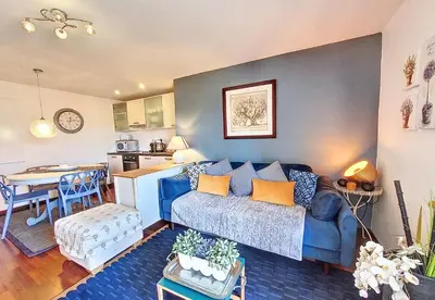 a living room with a blue couch and a kitchen at Nestor&Jeeves - CHAISE BLEUE - Central - Near Beach in Nice