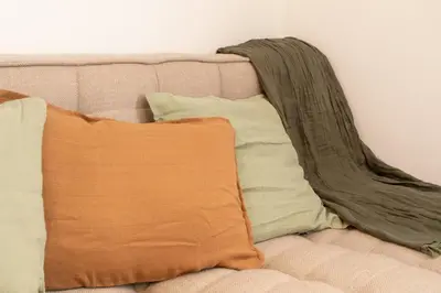 an orange pillow sitting on top of a couch at #41 Flat for 6, 3 Bdrs Parking Wifi 5mins walk Tram T1 in Nice