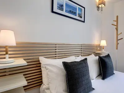 a bed with white pillows and a wooden headboard at Nestor&Jeeves - COZY CLOUD - Central - Near Beach in Nice