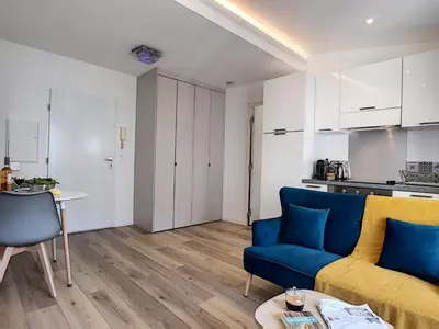 a living room with a blue couch and a kitchen at Nestor&Jeeves - COZY CLOUD - Central - Near Beach in Nice