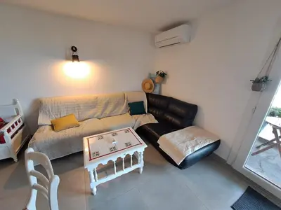 a living room with a couch and a table at Appartement spacieux & vue imprenable in Saint-Laurent-du-Var