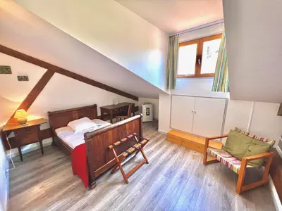 a attic room with a bed and a chair at E OP Duplex d Antoine Old Port - Old Town in Nice