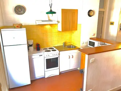 a small kitchen with white appliances and yellow tiles at E OP Duplex d Antoine Old Port - Old Town in Nice