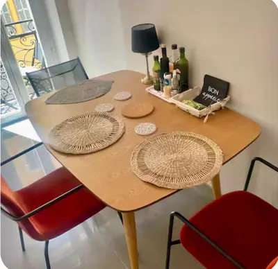 a wooden table with two chairs and bottles of wine at Suite Massena in Nice