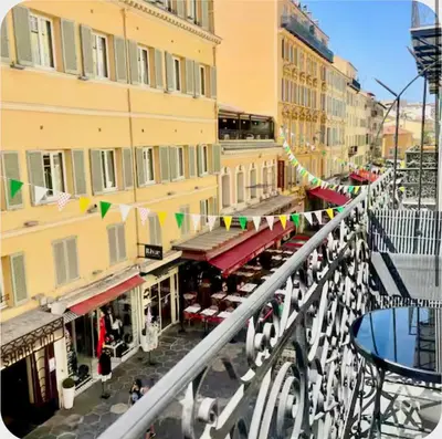 a city street with buildings and a bridge with flags at Suite Massena in Nice
