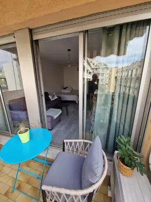 a small balcony with a blue table and chairs at Lory's home in Nice