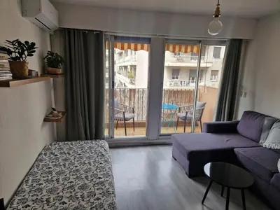 a living room with a purple couch and a balcony at Lory's home in Nice