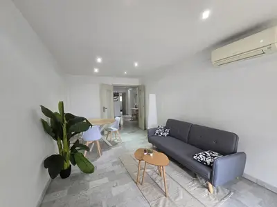 a living room with a couch and a table at Large T2 50m from the beaches in Nice