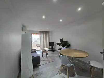 a living room with a table and a dining room at Large T2 50m from the beaches in Nice