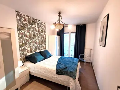a bedroom with a bed with blue pillows at Large T2 50m from the beaches in Nice