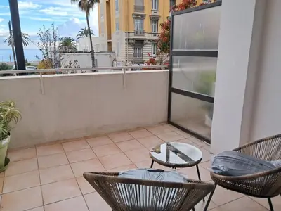 a patio with chairs and a table on a balcony at Large T2 50m from the beaches in Nice