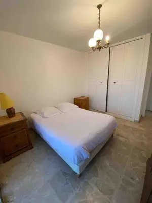 a bedroom with a large white bed and a chandelier at T2 Proche plage - Centre cagnes sur mer in Cagnes-sur-Mer