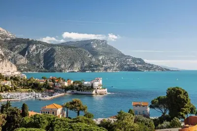a view of a town on the water with mountains at Magnifique T3 wifi, garage et climatisation à 5 min de la plage in Beaulieu-sur-Mer