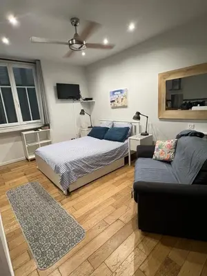 a bedroom with a bed and a couch at Coquette studio YourHostelper in Nice