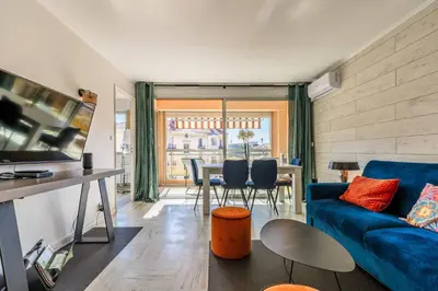 a living room with a blue couch and a table at Jolie studio avec belle terrasse ensoleillee in Nice