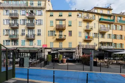 a large yellow building with a pool in front of it at Coquet studio place du pin in Nice
