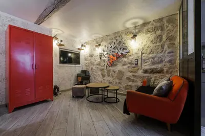 a living room with a red door and a table at Coquet studio place du pin in Nice