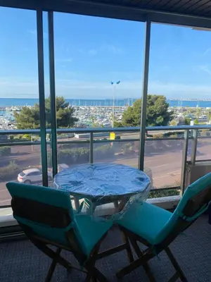 a table and a chair in front of a window at STUDIO SUPER AQUARAMA Bord de mer in Saint-Laurent-du-Var