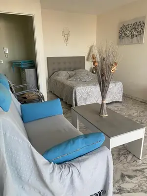 a bedroom with two beds and a table and a chair at STUDIO SUPER AQUARAMA Bord de mer in Saint-Laurent-du-Var
