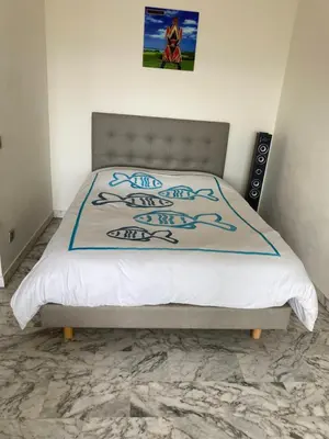 a bedroom with a bed with a comforter on it at STUDIO SUPER AQUARAMA Bord de mer in Saint-Laurent-du-Var