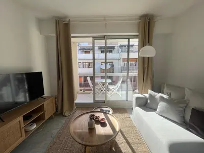 a living room with a couch and a table and a tv at apppartement avec terrasse - 2 à 4 personnes in Nice