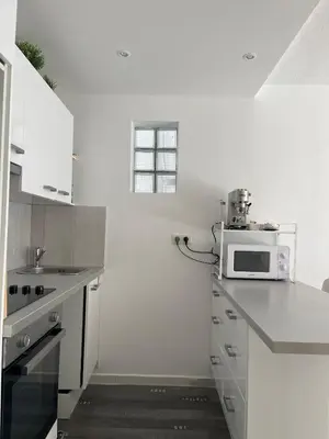a white kitchen with a microwave on a counter at apppartement avec terrasse - 2 à 4 personnes in Nice