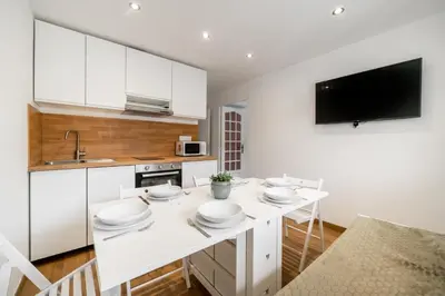 a kitchen with white cabinets and a white counter top at Modern apartment, steps from tramway in Nice