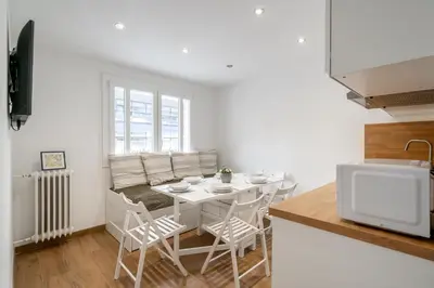 a kitchen and dining room with a table and chairs at Modern apartment, steps from tramway in Nice