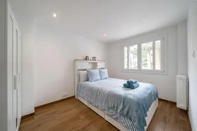 a white bedroom with a bed and a window at Modern apartment, steps from tramway in Nice