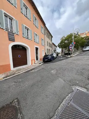 an empty street with a building with a garage at appartement maison de village in Cagnes-sur-Mer