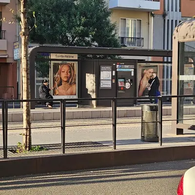 a bus stop with posters on the side of a street at Vue mer studio tout équipé in Nice