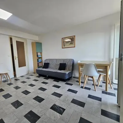 a living room with a couch and a table at Vue mer studio tout équipé in Nice
