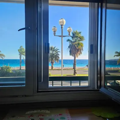 a room with a window looking out at the beach at Vue mer studio tout équipé in Nice