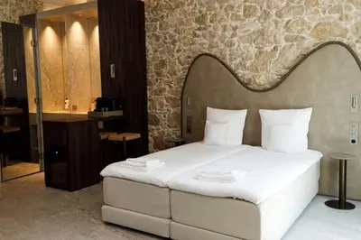 a bedroom with a large bed and a bathroom at Notre Dame Hotel - Self Check-in in Nice