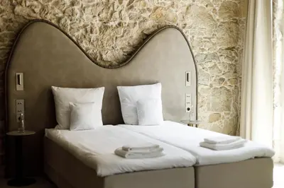 a hotel room with a bed with a large headboard at Notre Dame Hotel - Self Check-in in Nice