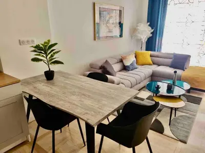 a living room with a table and a couch at L38 Hobeika Suite Fleur 7min Walk To Beach,Free Park,Balc&AC in Nice