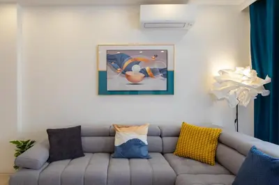 a living room with a gray couch with pillows at L38 Hobeika Suite Fleur 7min Walk To Beach,Free Park,Balc&AC in Nice