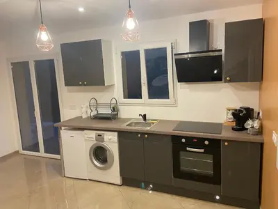 a kitchen with a sink and a washing machine at Appartement T3 dans une villa au calme in Drap