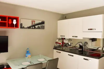 a kitchen with white cabinets and a table with chairs at Studio avec terrasse à Nice in Nice